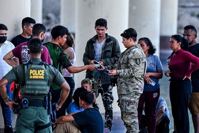 Migrants are apprehended by US Border Patrol and National Guard troops in Eagle Pass, Texas, near the border with Mexico on June 30, 2022. (Photo by CHANDAN KHANNA/AFP via Getty Images)