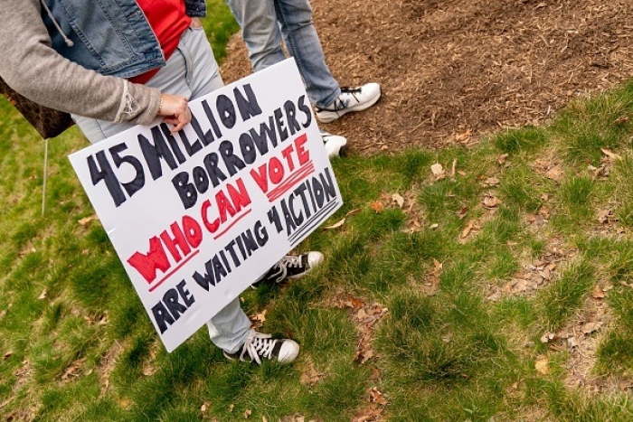 A protest sign at a Cancel Student Debt rally outside the US Department of Education in Washington, D.C., on April 4, 2022. (Photo by STEFANI REYNOLDS/AFP via Getty Images)