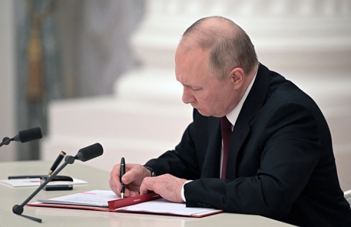 Russian President Vladimir Putin signs documents last February recognizing the two Russian-backed separatist regions of Donetsk and Luhansk as “independent.” (Photo by Alexey Nikolsky/Sputnik/AFP via Getty Images)