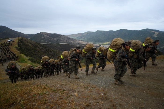 Female U.S. Marine Corps recruits from Lima Company, the first gender-integrated training class at Camp Pendleton in San Diego, carry 60 pound packs at the end of their 9.7 mile hike on April 22, 2021. (Photo by PATRICK T. FALLON/AFP via Getty Images)