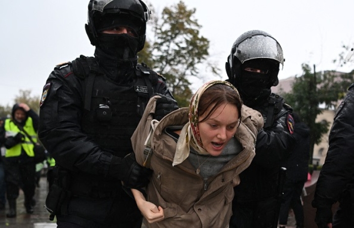Police officers detain a woman in Moscow on September 24, 2022, following calls to protest against the mobilization of military reservists announced by Russian President Vladimir Putin.(Photo by AFP via Getty Images)