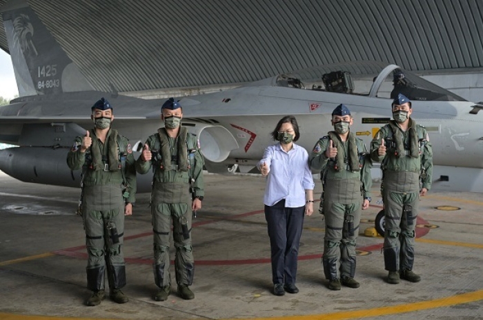 Taiwan President Tsai Ing-wen (C) poses for photographs with air force crews in front of a fighter jet at an air force base on Penghu islands, Taiwan Strait, on August 30, 2022. (Photo by SAM YEH/AFP via Getty Images)