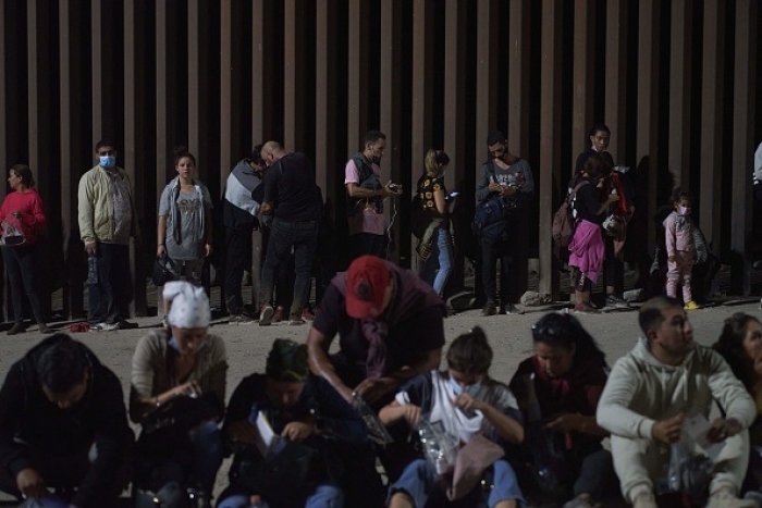 Migrants wait to be processed by US Border Patrol after illegally crossing the US-Mexico border in Yuma, Arizona in the early morning of July 11, 2022. (Photo by ALLISON DINNER/AFP via Getty Images)