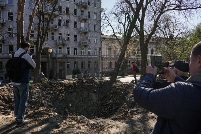 Ukrainians take photos in Kyiv of a crater left by one of scores of Russian missile strikes targeting the capital and other cities this week. (Photo by Elizabeth Servatynska / Suspilne Ukraine/JSC &quot;UA:PBC&quot; / Global Images Ukraine via Getty Images)