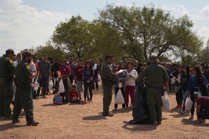 This picture taken on October 9, 2022 shows migrants being processed by US Border Patrol after they illegally crossed the US southern border with Mexico in Eagle Pass, Texas. (Photo by ALLISON DINNER/AFP via Getty Images)