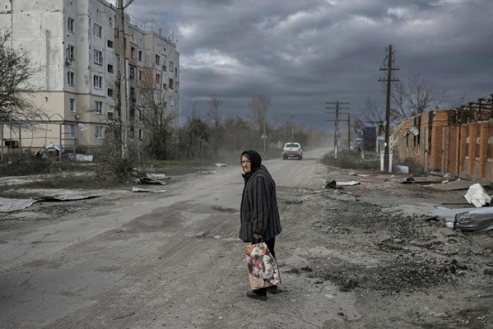 An elderly woman walks in a battle-ravaged street in Arkhanhelske, a village in the Kherson region recently vacated by Russian forces. (Photo by Bulent Kilic / AFP via Getty Images