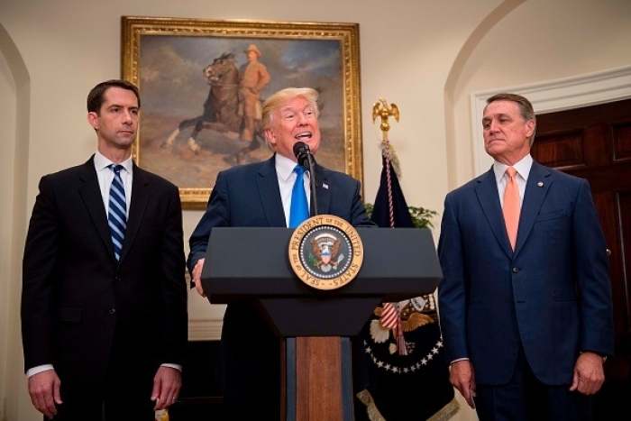 President Donald Trump makes an immigration announcement, flanked by Sens. Tom Cotton and David Perdue, on August 2, 2017. (Photo by JIM WATSON/AFP via Getty Images)