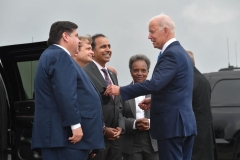 President Joe Biden greets Chicago Mayor Lori Lightfoot (2nd-R), Illinois Governor J.B. Pritzker (L), Rep. Mike Quigley (2n-L) and Rep. Raja Krishnamoorthi (3rd-L) as he disembarks from Air Force One upon arrival at O'Hare International Airport in Chicago, Illinois, October 7, 2021, to promote the importance of Covid-19 vaccine requirements. (Photo by NICHOLAS KAMM/AFP via Getty Images)