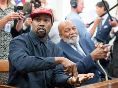 View of American rapper and producer Kanye West, gesturing with his hands, in the White House's Oval Office, Washington DC, October 11, 2018. He wears a red baseball cap that reads 'Make America Great Again.' Visible to West's left is American retired professional football player Jim Brown. (Photo by Ron Sachs/Consolidated News Pictures/Getty Images)